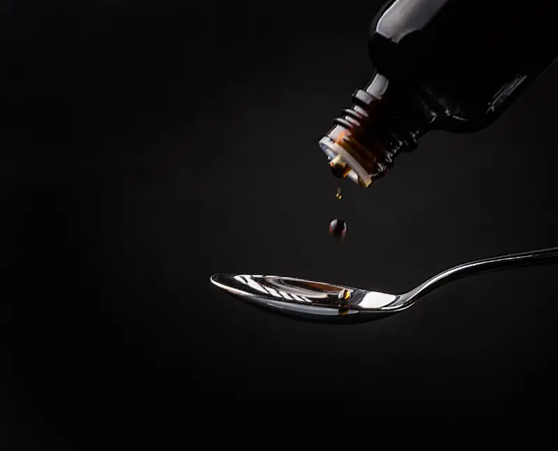 Medicine being dispensed on a spoon