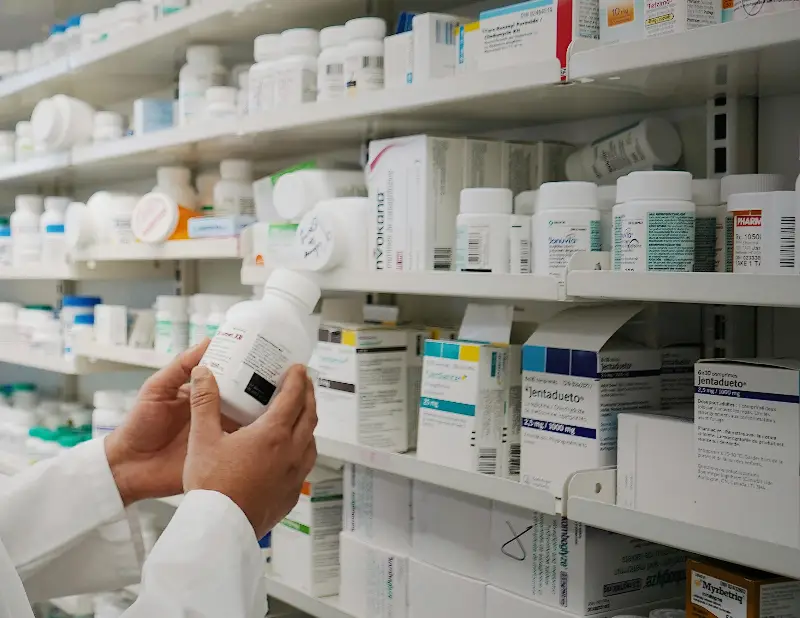 Pharmacist in front of Shelves with Medicines